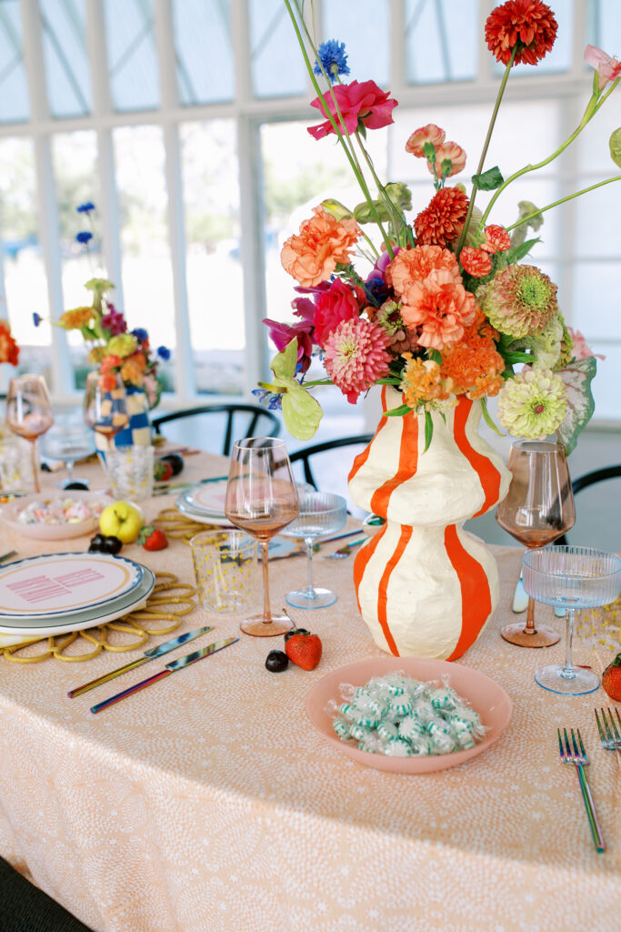 Bright striped floral vase by Loam on wedding table.